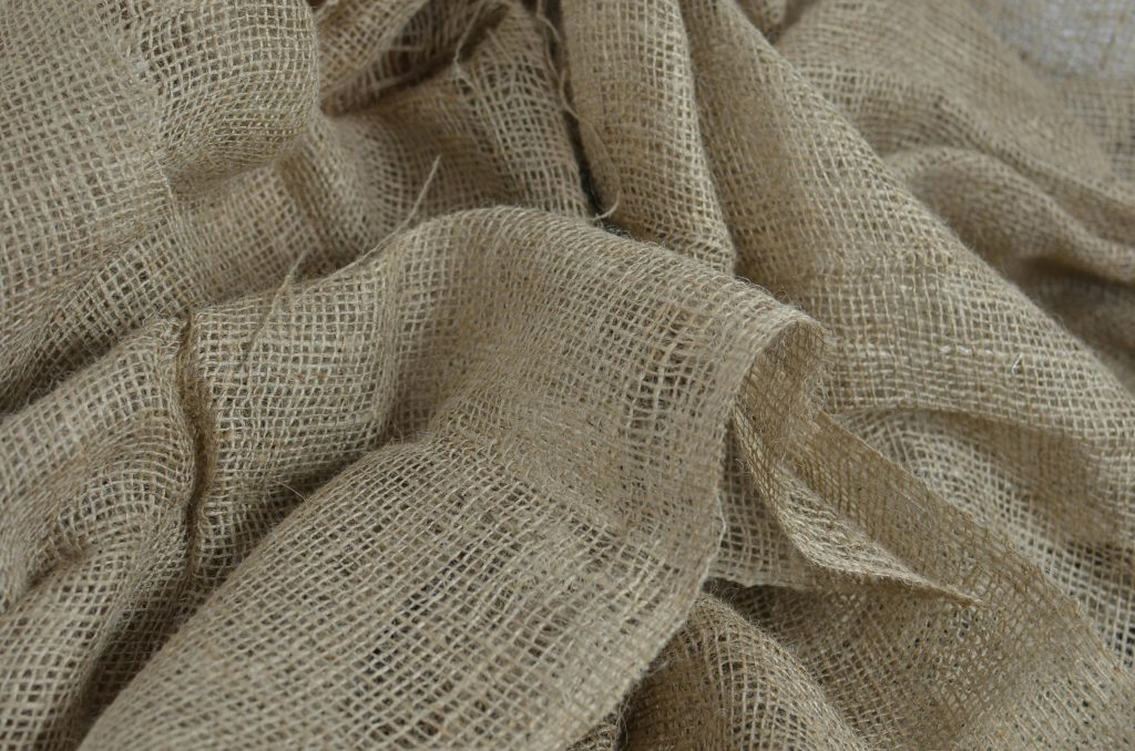 Close-up view of crumpled burlap fabric showing intricate texture and organic patterns.